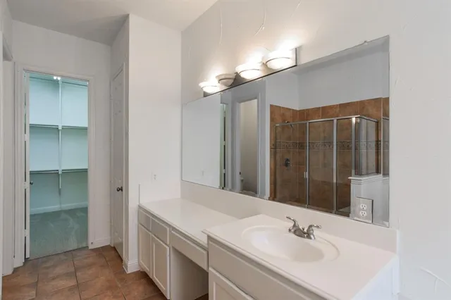 a bathroom with a double vanity sink a mirror and a shower
