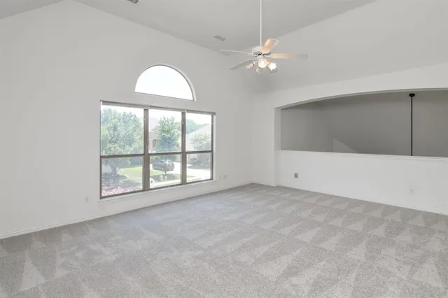 an empty room with chandelier fan