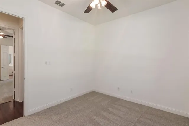 an empty room with a chandelier fan