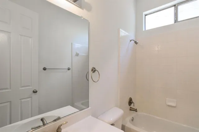 a bathroom with a tub a sink and mirror