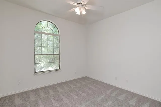an empty room with a window and a chandelier