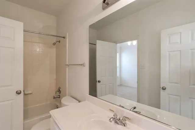 a bathroom with a bathtub shower sink and mirror