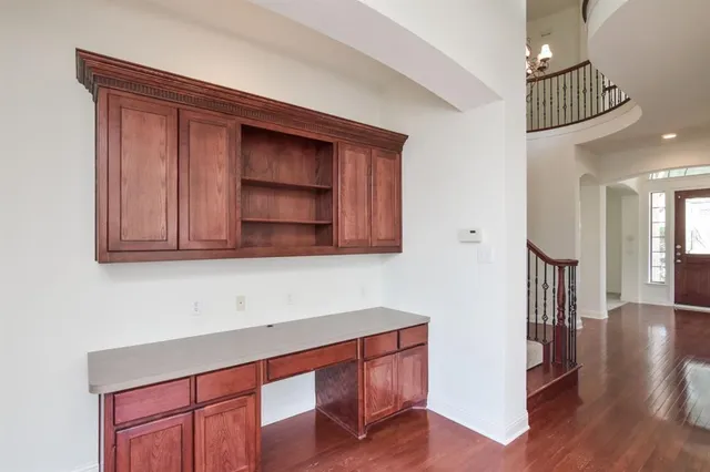 a hallway with wooden floor and cabinet