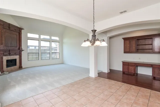 a view of an empty room with a fireplace and a window