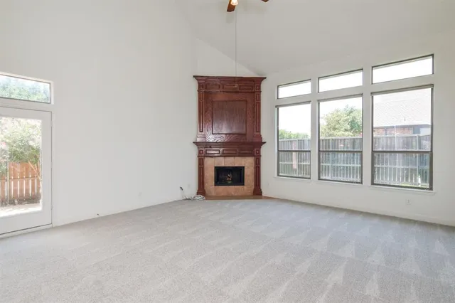 a view of an empty room with a fireplace and a window