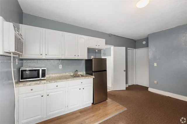 a kitchen with stainless steel appliances white cabinets and a refrigerator