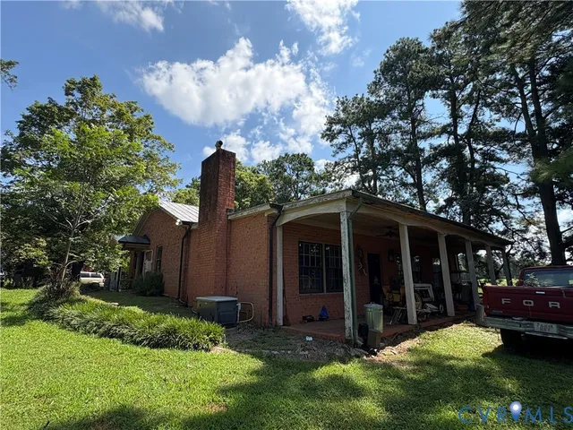 a view of a house with a yard and potted plants