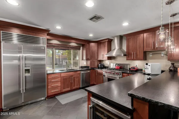 a kitchen with stainless steel appliances granite countertop sink stove top oven and cabinets