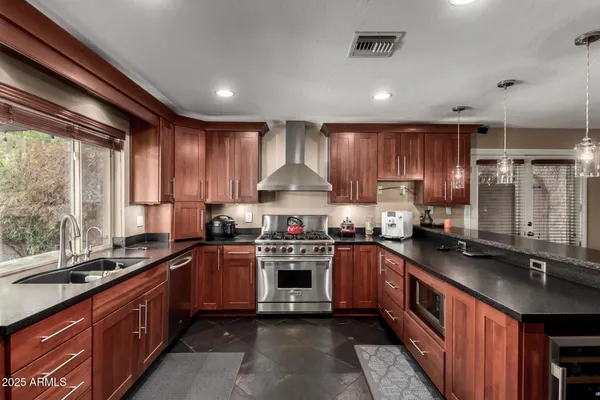 a kitchen with stainless steel appliances granite countertop a sink stove and cabinets