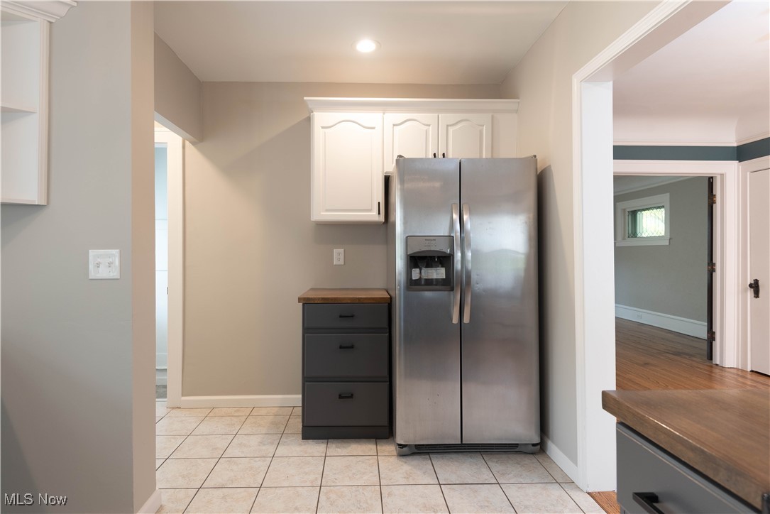 7003 Brecksville Road Independence, OH 44131 - Photo 18 of 35 Kitchen featuring white cabinetry, stainless steel refrigerator with ice dispenser, light tile patterned floors, and wood counters