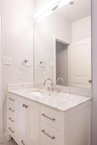 a bathroom with a granite countertop sink and a mirror