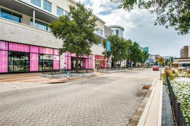 a view of street with a building and cars parked on the roadside