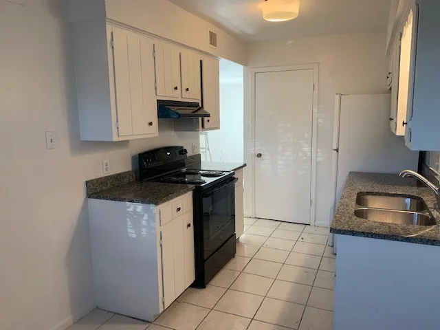 a kitchen with a sink stove and cabinets
