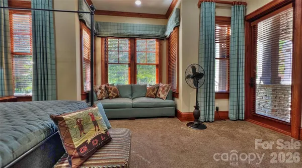 a bed sitting in a spacious bedroom next to a window