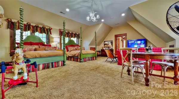 a spacious bedroom with a bed and a chandelier