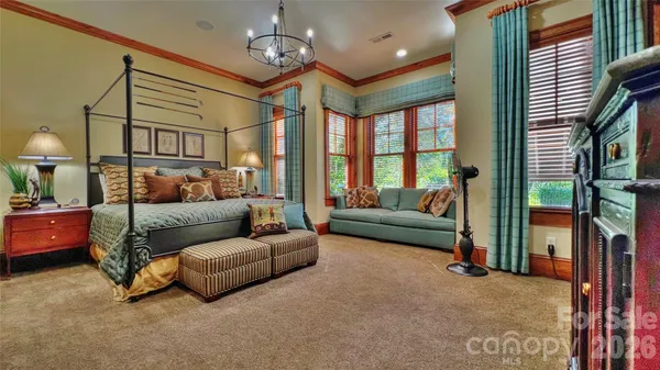 a bedroom with a large bed and a chandelier