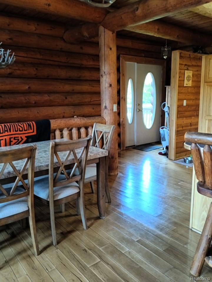 10374 Wilson Road Otisville, MI 48463 - Photo 48 of 99 Dining space featuring beam ceiling, light wood-style floors, and log walls