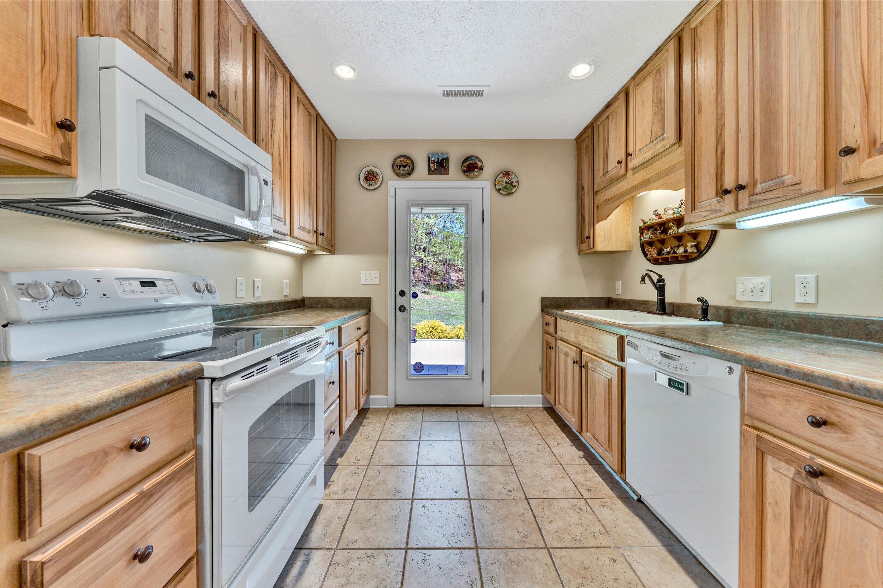 1186 Camp Jaycee Road Blue Ridge, VA 24064 - Photo 15 of 54 a kitchen with stainless steel appliances granite countertop a stove a sink and a microwave