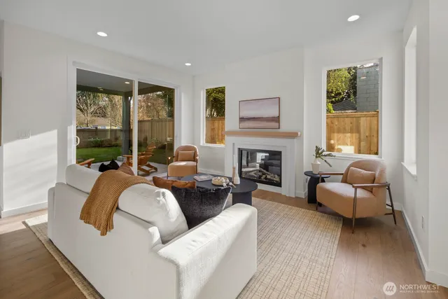 a living room with fireplace furniture and a large window