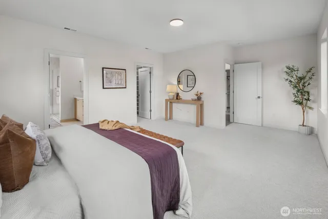 a bedroom with a bed and potted plant on dresser