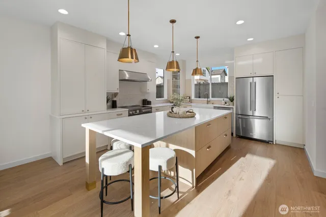 a kitchen with kitchen island a sink appliances and cabinets