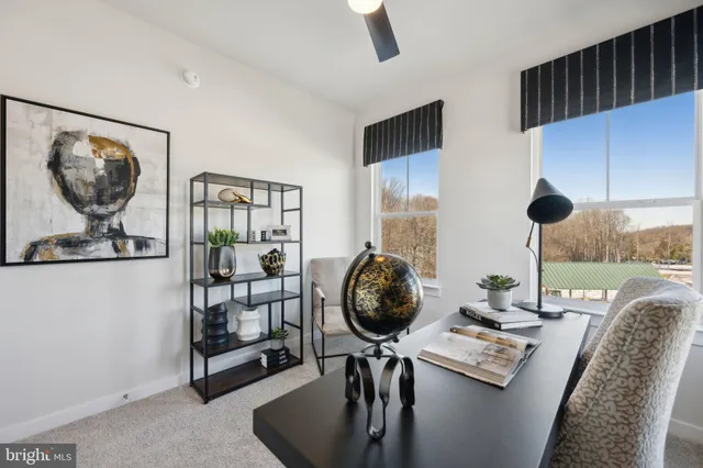 a view of a workspace with furniture and a floor to ceiling window