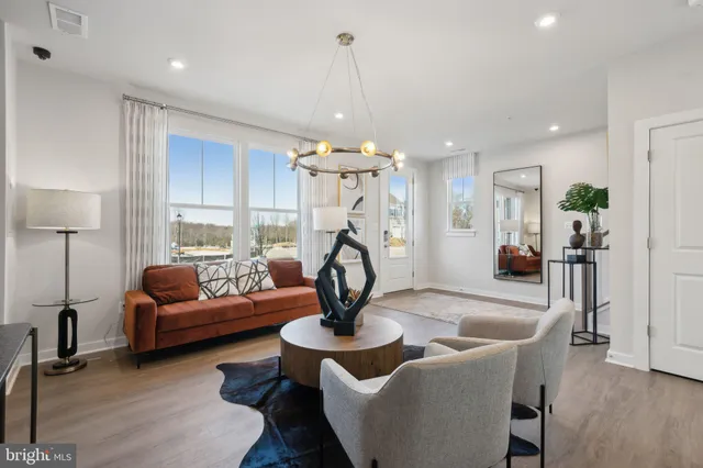 a living room with furniture a chandelier and a wooden floor