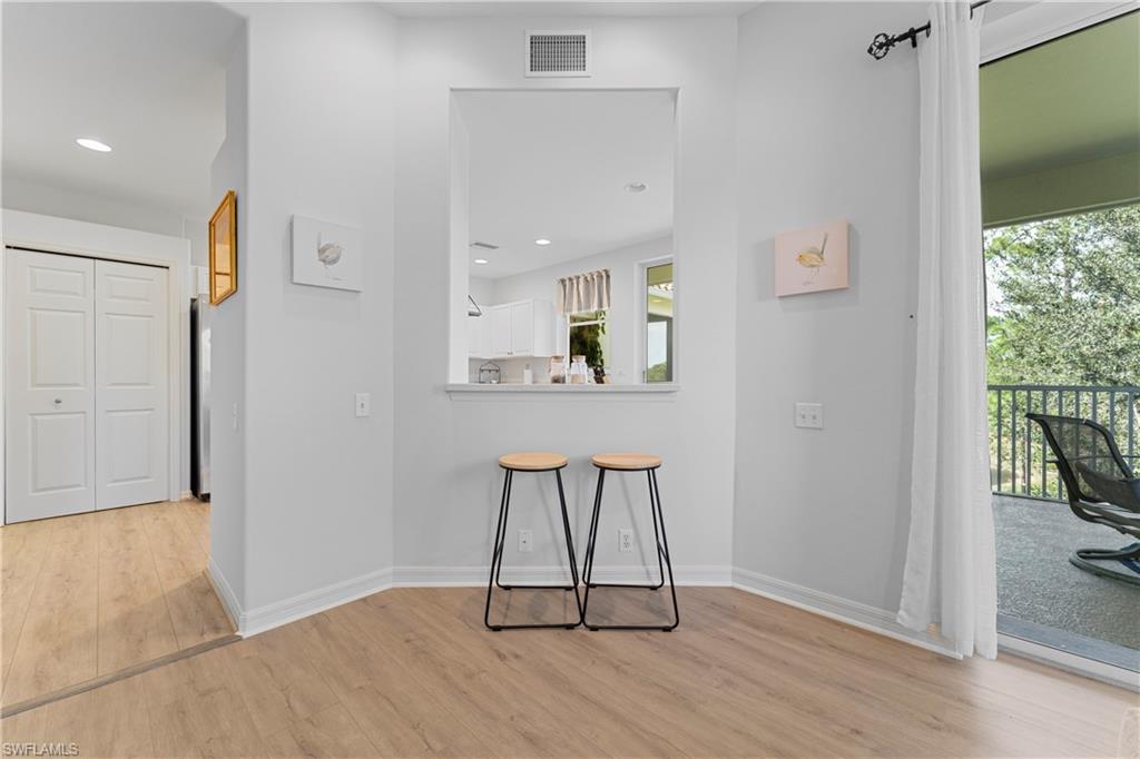 8217 Parkstone Place, Unit 308 Naples, FL 34120 - Photo 16 of 50 a view of a hallway with wooden floor and a living room