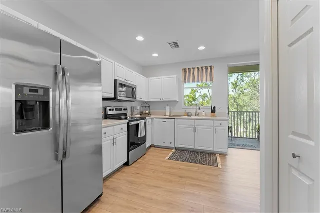 a kitchen with granite countertop a refrigerator and a stove top oven
