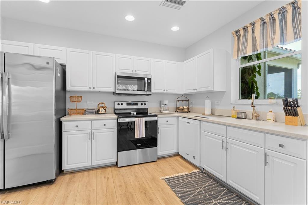 8217 Parkstone Place, Unit 308 Naples, FL 34120 - Photo 18 of 50 a kitchen with white cabinets and appliances