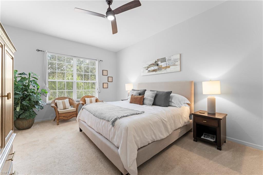 8217 Parkstone Place, Unit 308 Naples, FL 34120 - Photo 22 of 50 a bedroom with a bed and a chandelier