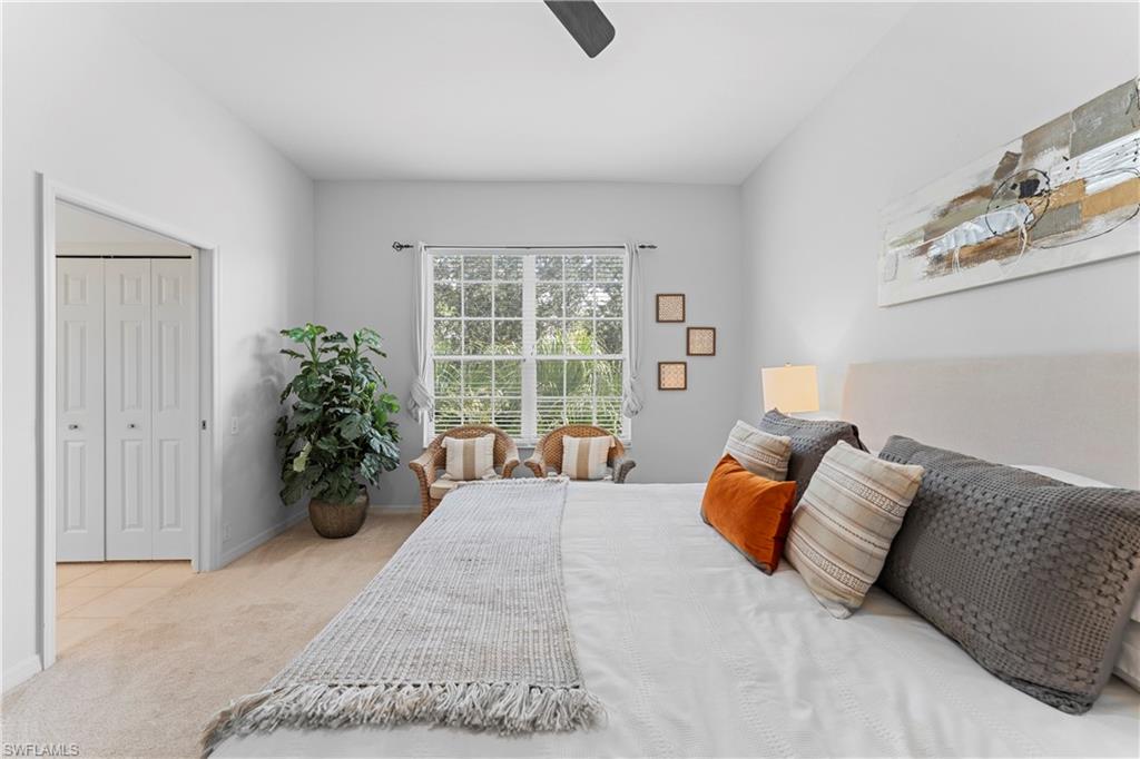 8217 Parkstone Place, Unit 308 Naples, FL 34120 - Photo 23 of 50 a bedroom with a bed and potted plants next to a large window