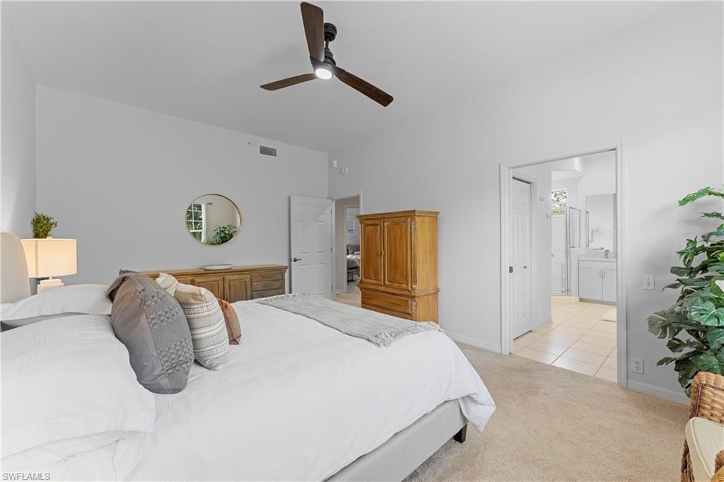 8217 Parkstone Place, Unit 308 Naples, FL 34120 - Photo 24 of 50 a bedroom with a bed and painting on the wall