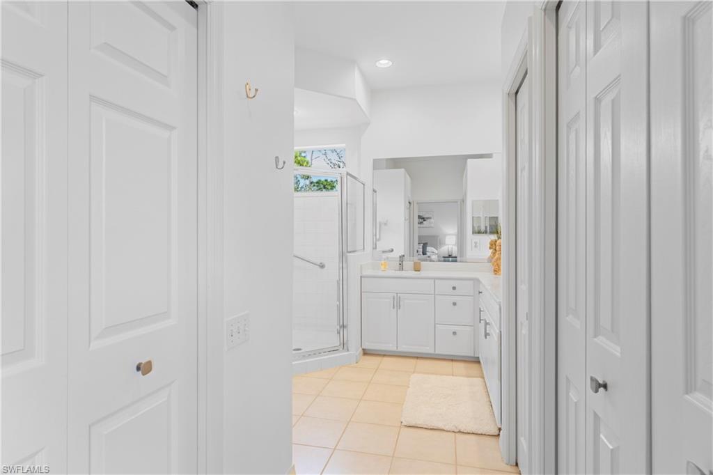 8217 Parkstone Place, Unit 308 Naples, FL 34120 - Photo 25 of 50 a bathroom with a granite countertop sink a vanity and a mirror