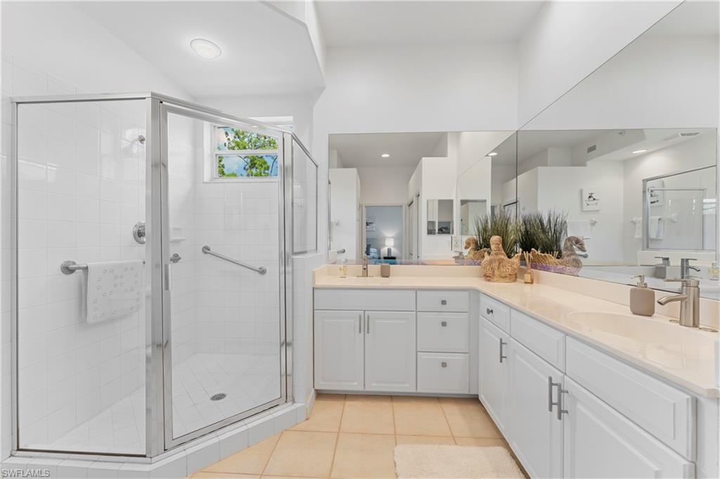 8217 Parkstone Place, Unit 308 Naples, FL 34120 - Photo 26 of 50 a spacious bathroom with a shower a sink and mirror