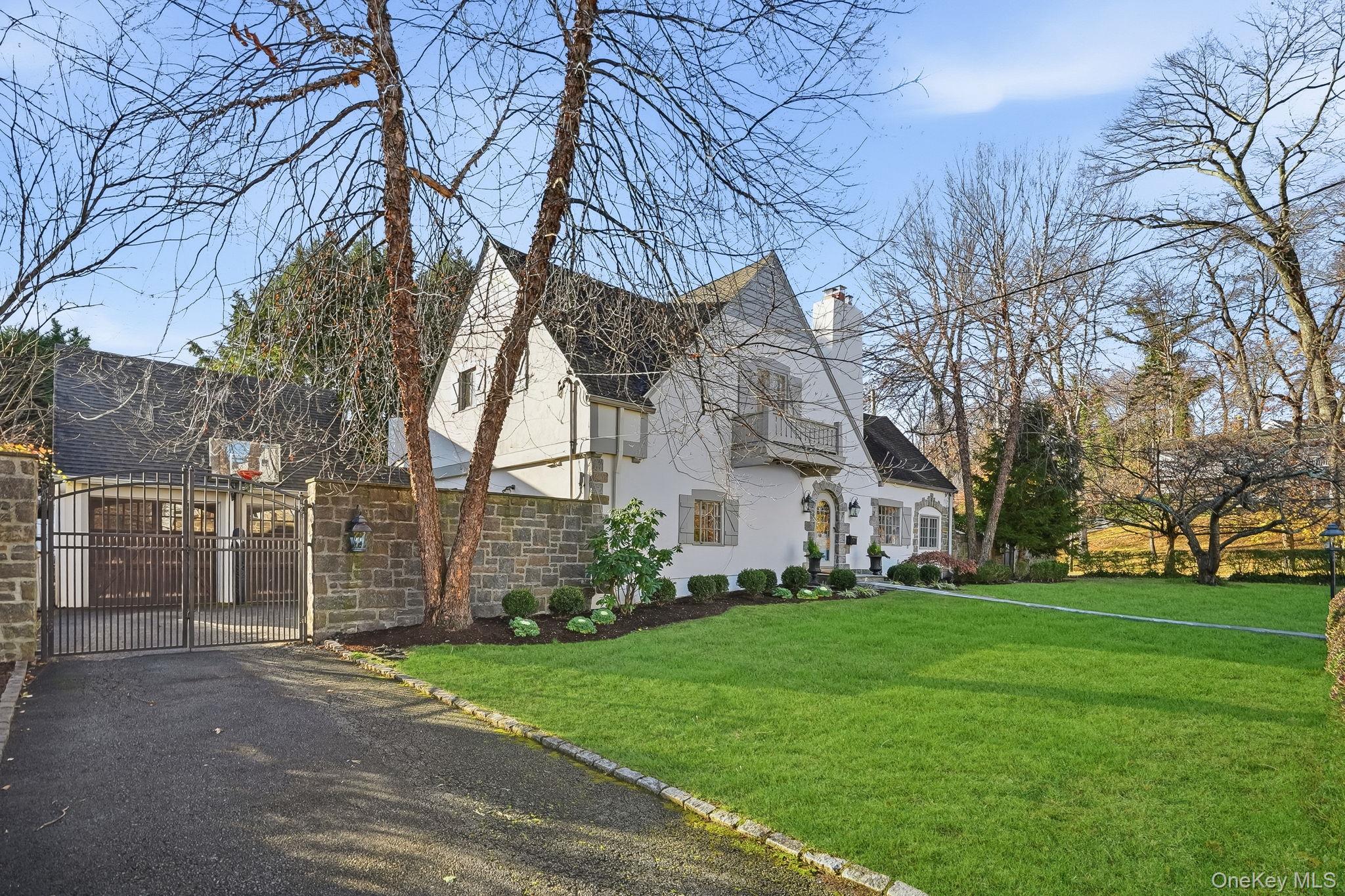 1 Oneida Street Rye, NY 10580 - Photo 2 of 32 a view of a white house next to a yard with large trees