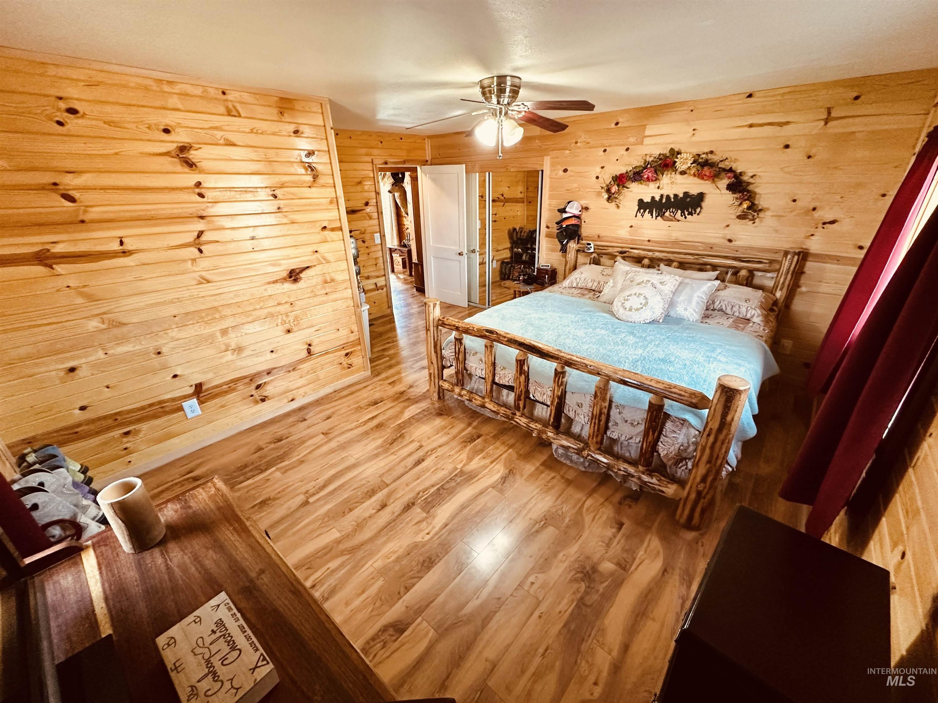 5051 South Rd J Vale, OR 97918 - Photo 17 of 49 Bedroom with wooden walls, wood finished floors, and a ceiling fan