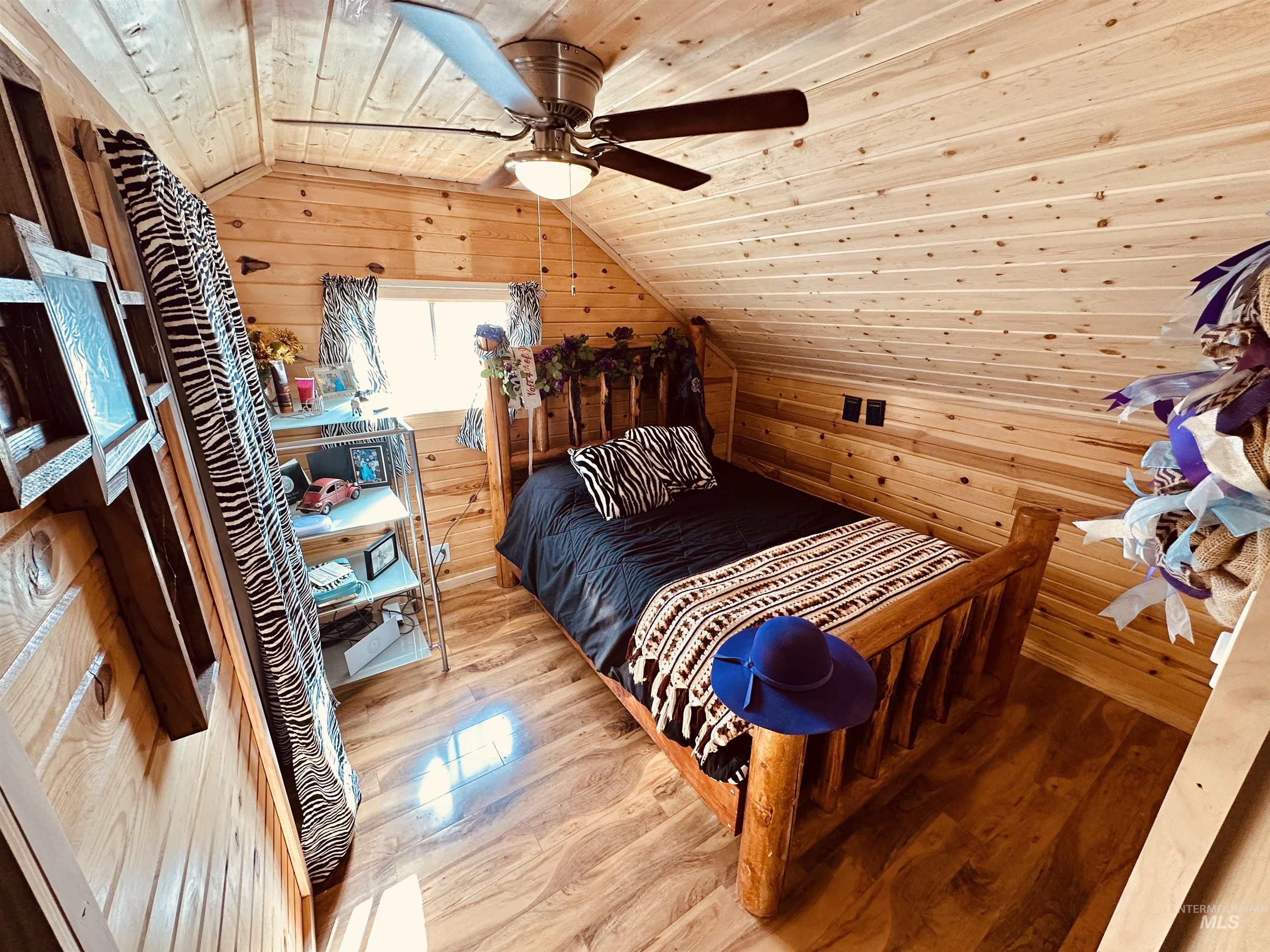 5051 South Rd J Vale, OR 97918 - Photo 19 of 49 Bedroom with wood walls, a vaulted wood ceiling, a ceiling fan, and wood finished floors