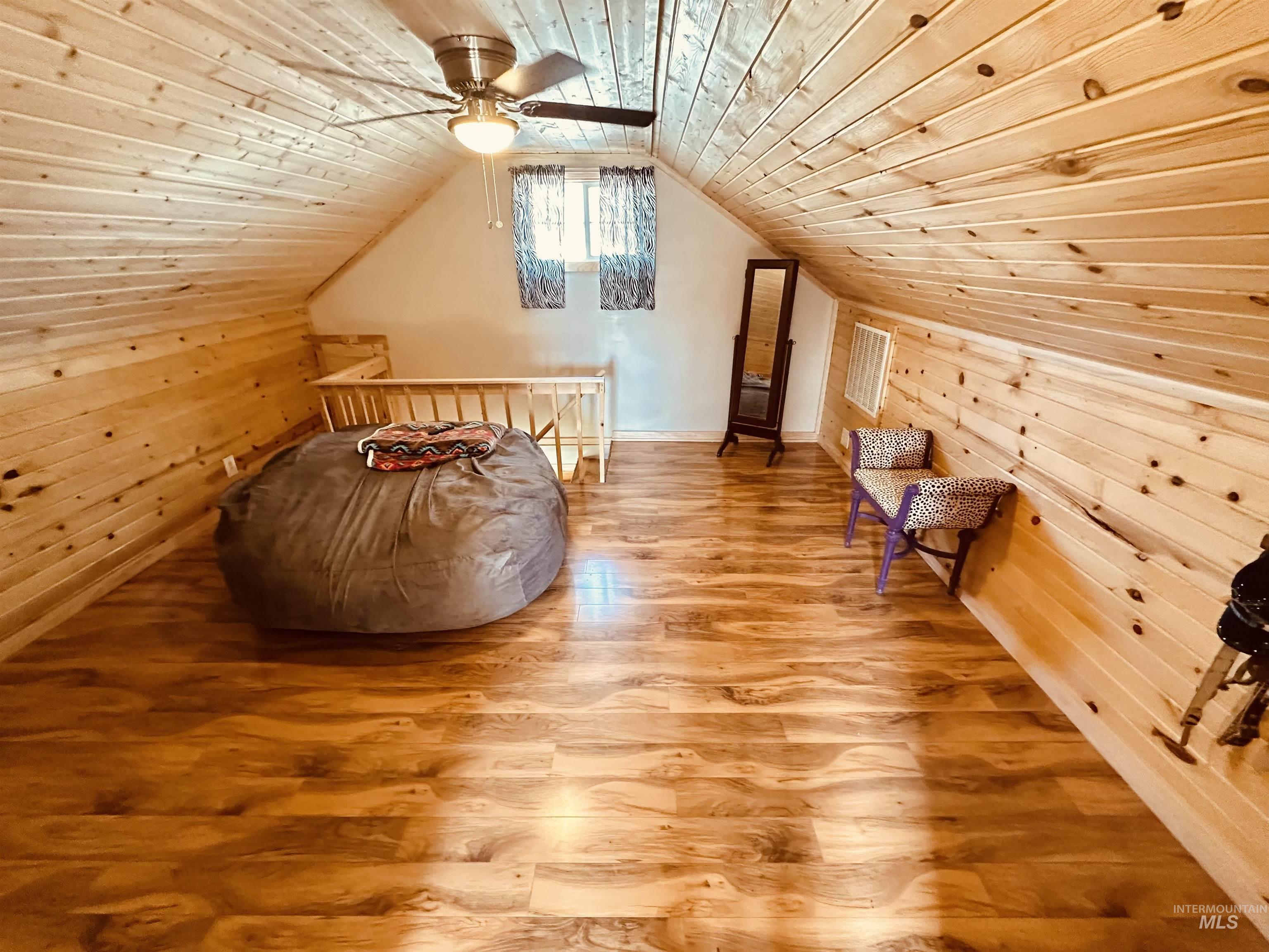 5051 South Rd J Vale, OR 97918 - Photo 20 of 49 Additional living space with wooden ceiling, wood walls, wood finished floors, and ceiling fan