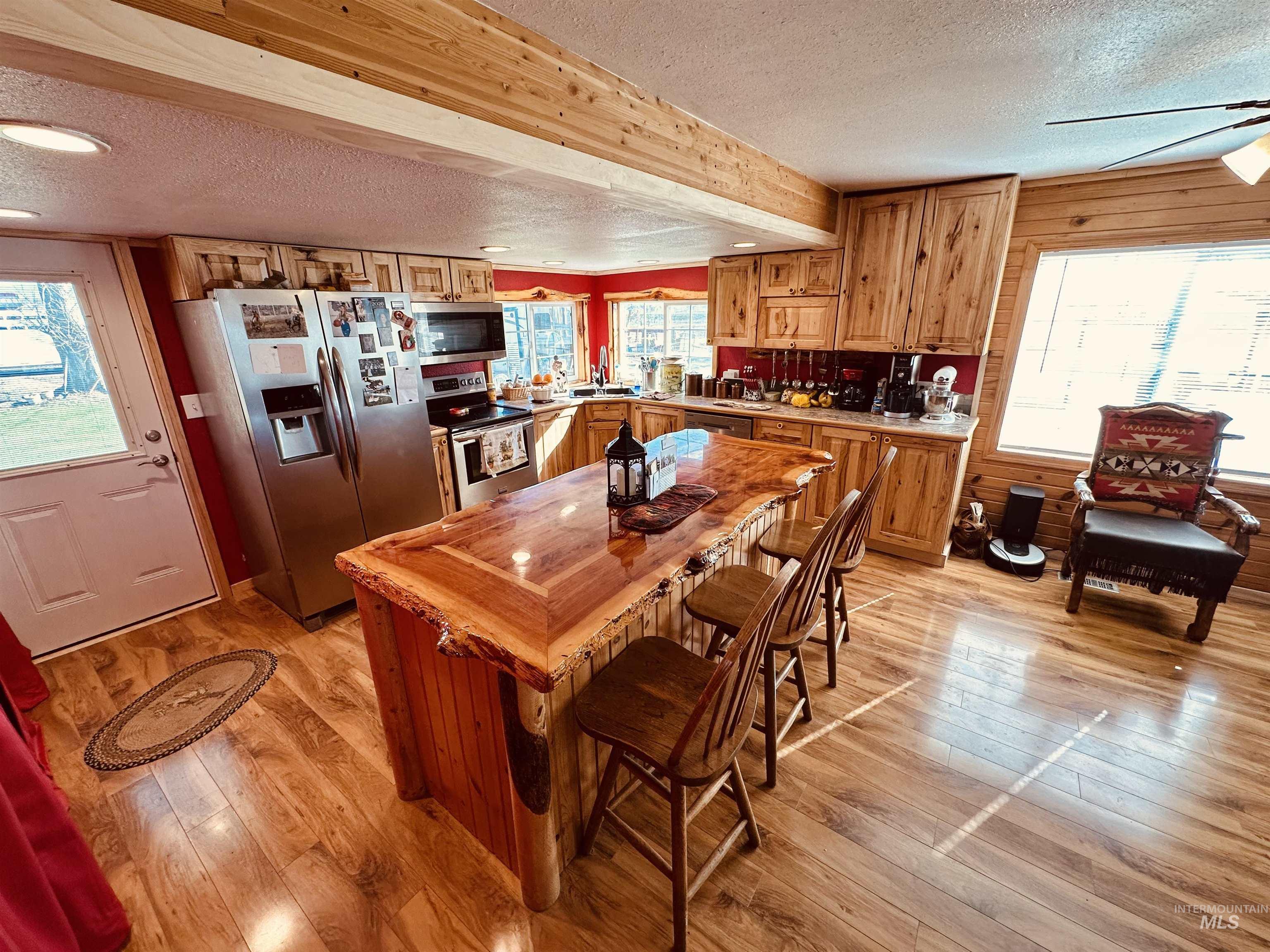 5051 South Rd J Vale, OR 97918 - Photo 4 of 49 Kitchen featuring stainless steel appliances, light wood-style floors, wood finish cabinetry, a textured ceiling, and butcher block countertops