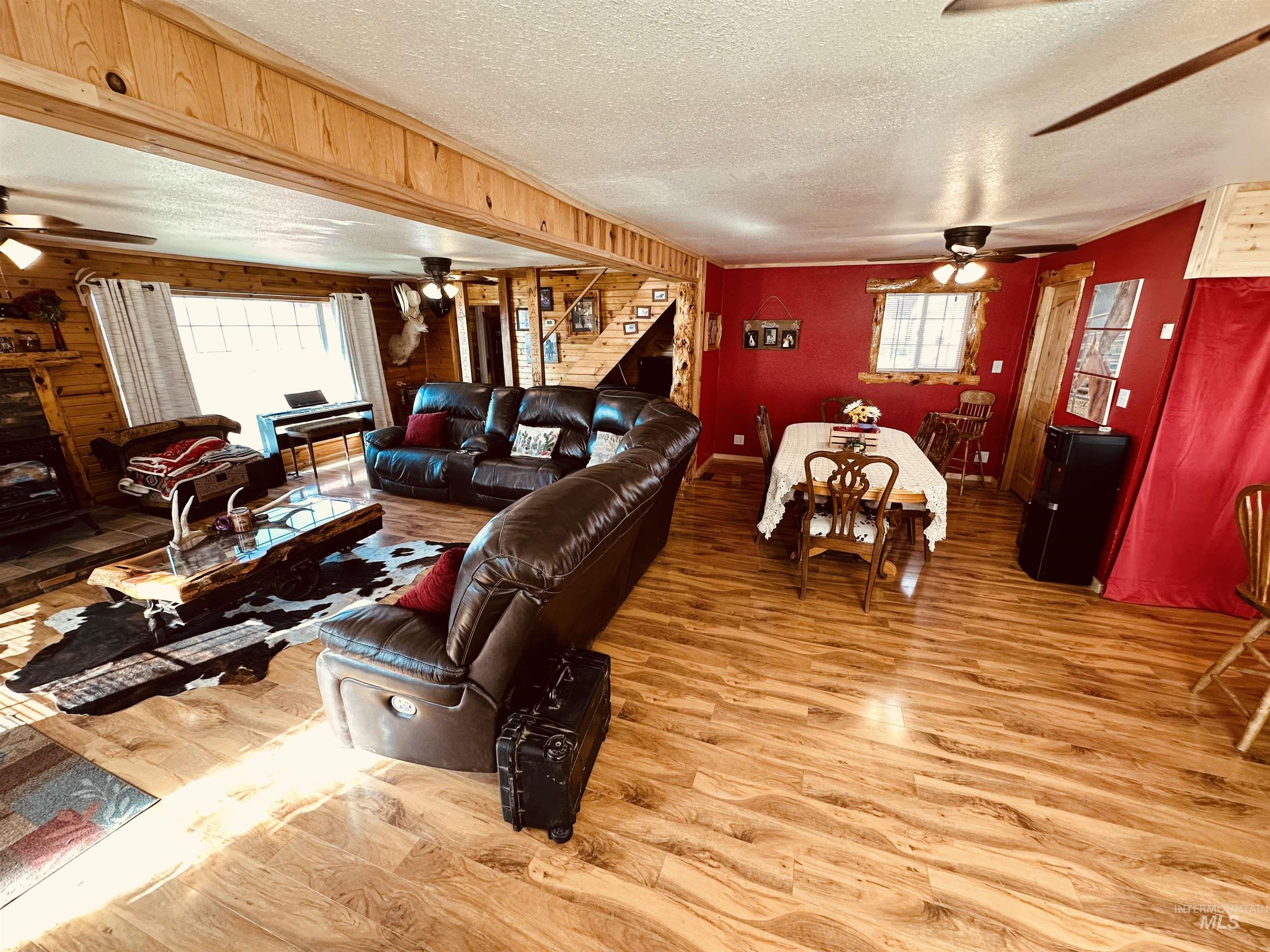 5051 South Rd J Vale, OR 97918 - Photo 8 of 49 Living area featuring a ceiling fan, wood finished floors, a textured ceiling, and wood walls
