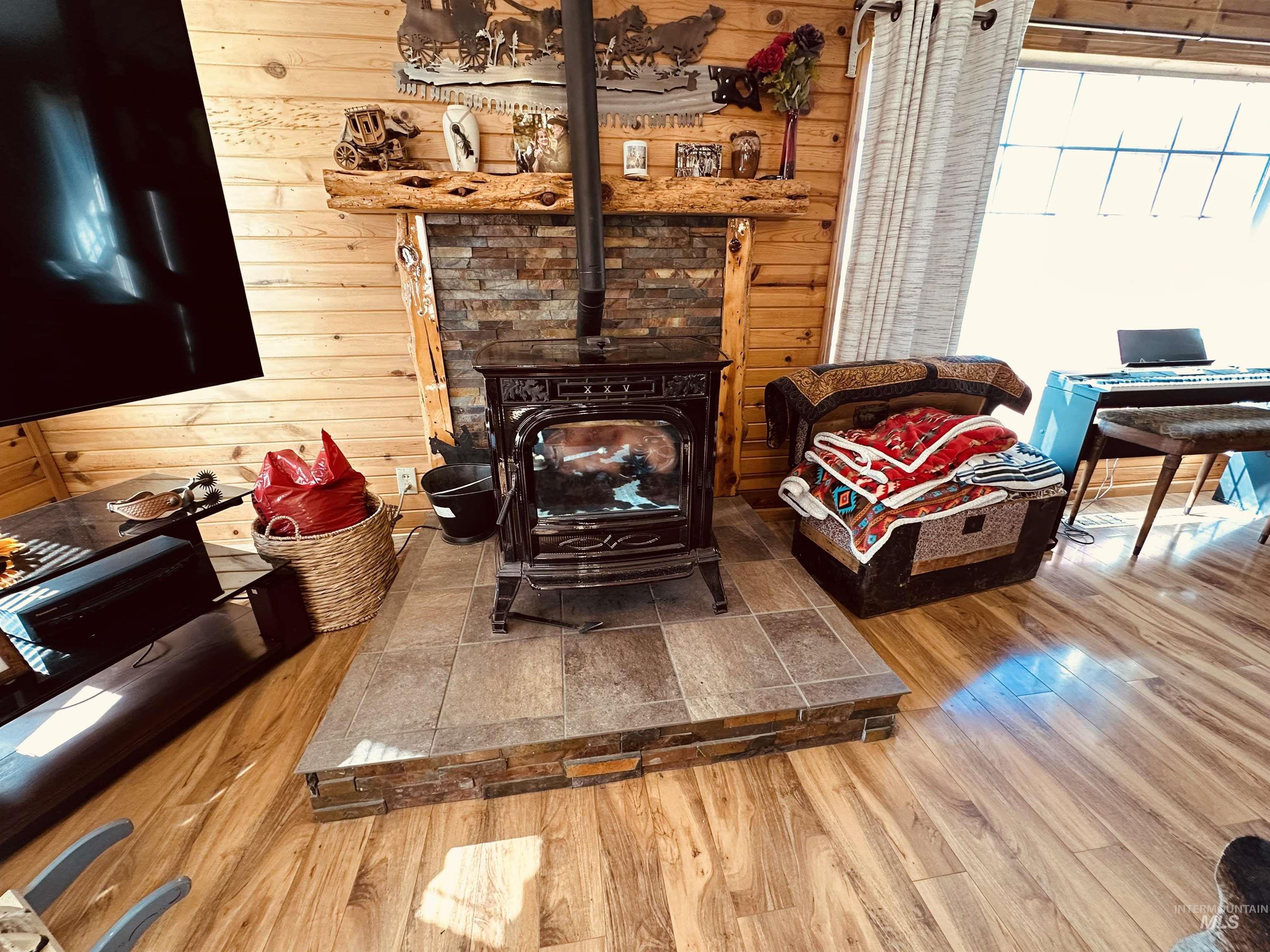 5051 South Rd J Vale, OR 97918 - Photo 9 of 49 Detailed view of wood finished floors, wood walls, and a wood stove
