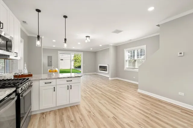 a kitchen with stainless steel appliances granite countertop a stove a sink and a wooden floors