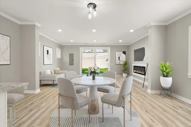 a view of a dining room with furniture a potted plant and wooden floor