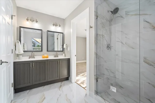 a bathroom with a double vanity sink mirror and shower
