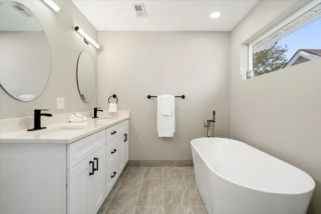 a bathroom with a double vanity sink and a mirror