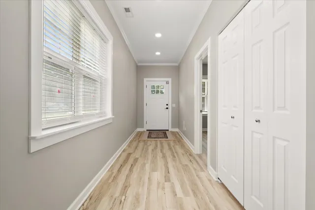 a view of a hallway with wooden floor and a window