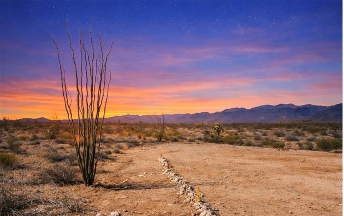 13811-13799 Alan Road Yucca, AZ 86438 - Photo 10 of 10 The property features a vast expanse of desert landscape with distant mountains under a colorful sky