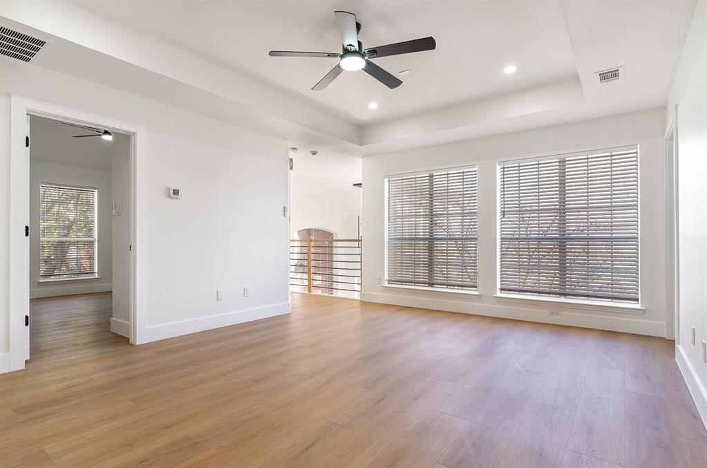 7524 Aberdon Road Dallas, TX 75252 - Photo 21 of 39 Unfurnished room featuring light wood-type flooring, visible vents, and a tray ceiling
