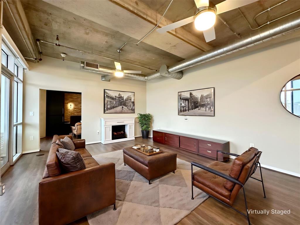 1001 Belleview Street, Unit 307 Dallas, TX 75215 - Photo 28 of 40 a living room with furniture a fireplace and a flat screen tv